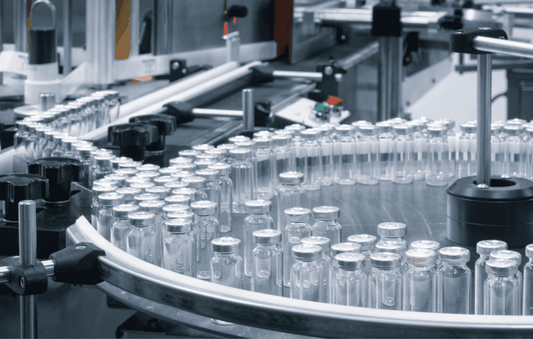 An inventory of clear bottles with silver caps getting funneled into a production line.